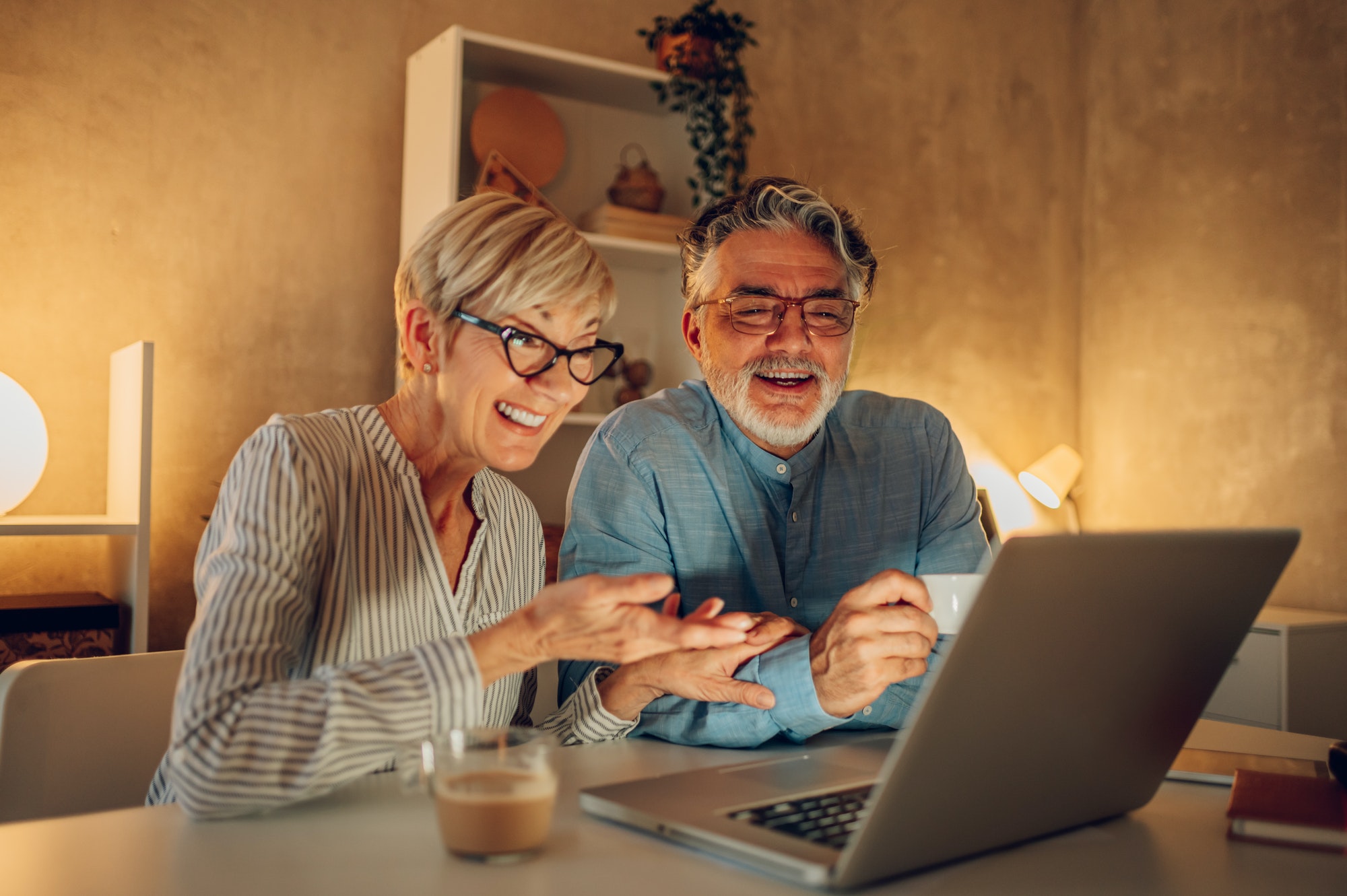 Senior couple using a laptop at home while having a video call